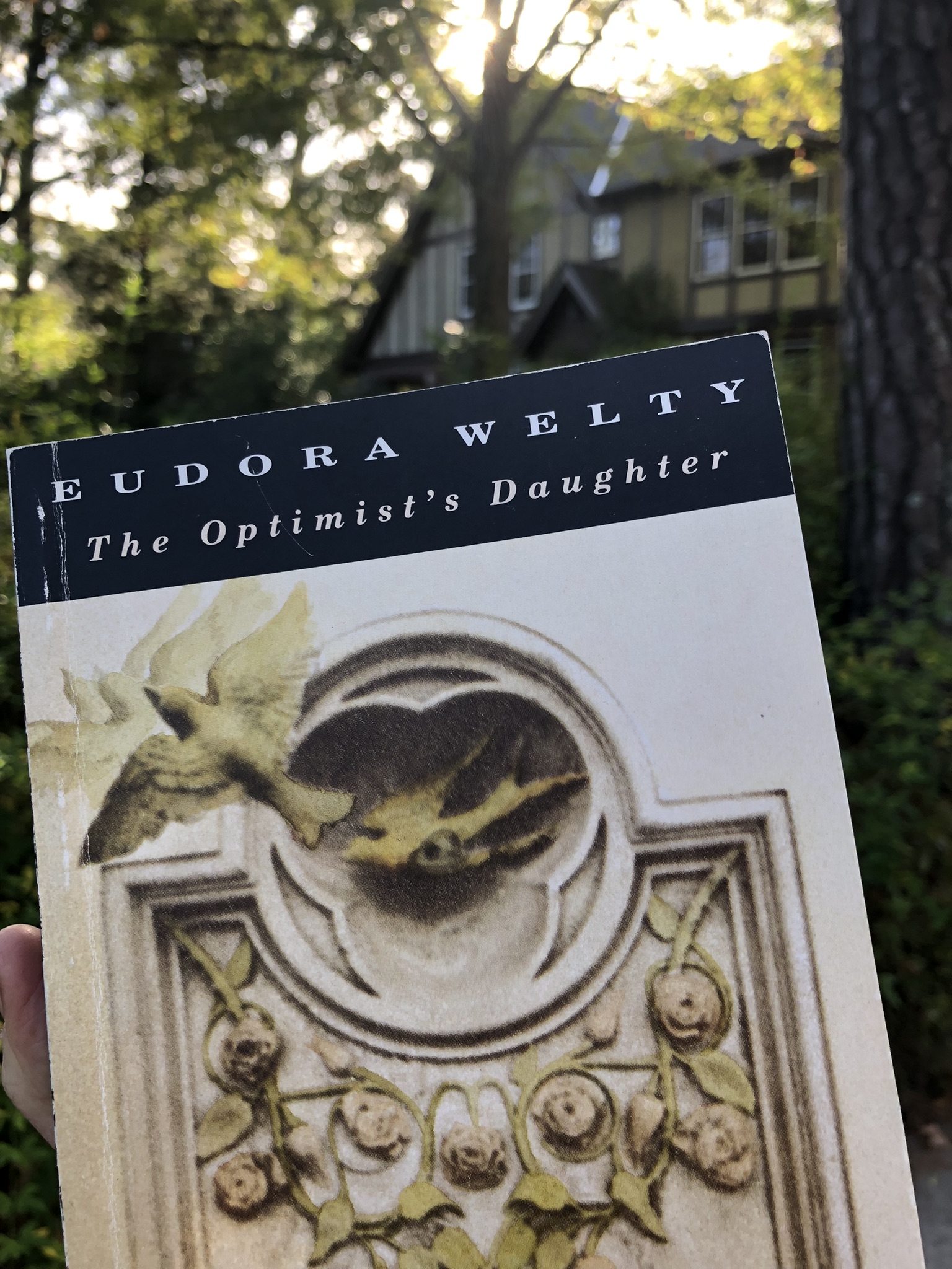 Cover of The Optimist's Daughter by Eudora Welty Vintage International Edition in front of Eudora Welty House