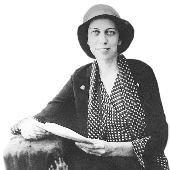 Eudora Welty around age twenty in a cloche hat, geometric patterned blouse, and matching trimmed blazer, holding a letter in an envelope.