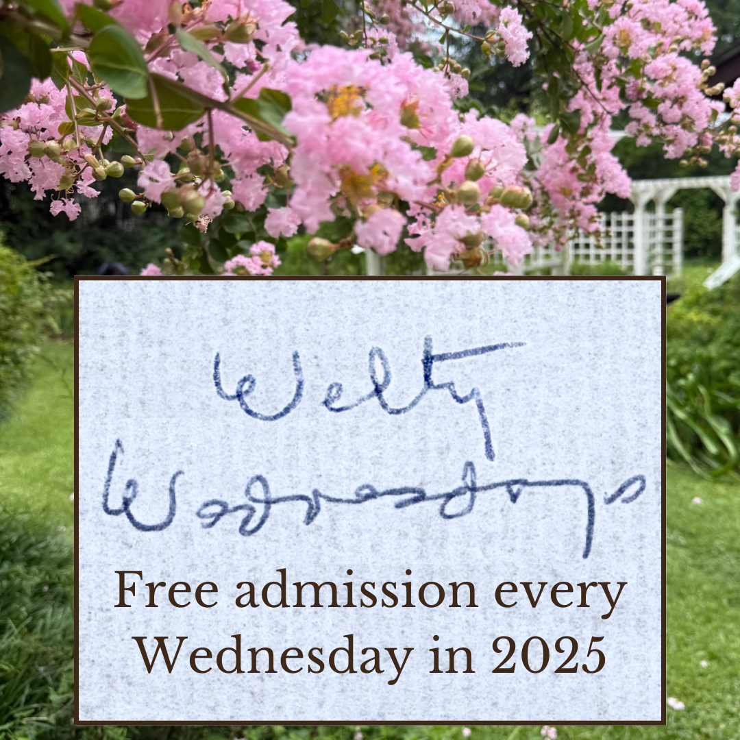 Pink crape myrtle blossoms fill the top of the frame in the Welty Garden, with a white trellis visible in the background. In the foreground, a square overlay features “Welty Wednesdays” in Eudora Welty’s handwriting above the text: “Free admission every Wednesday in 2025.”