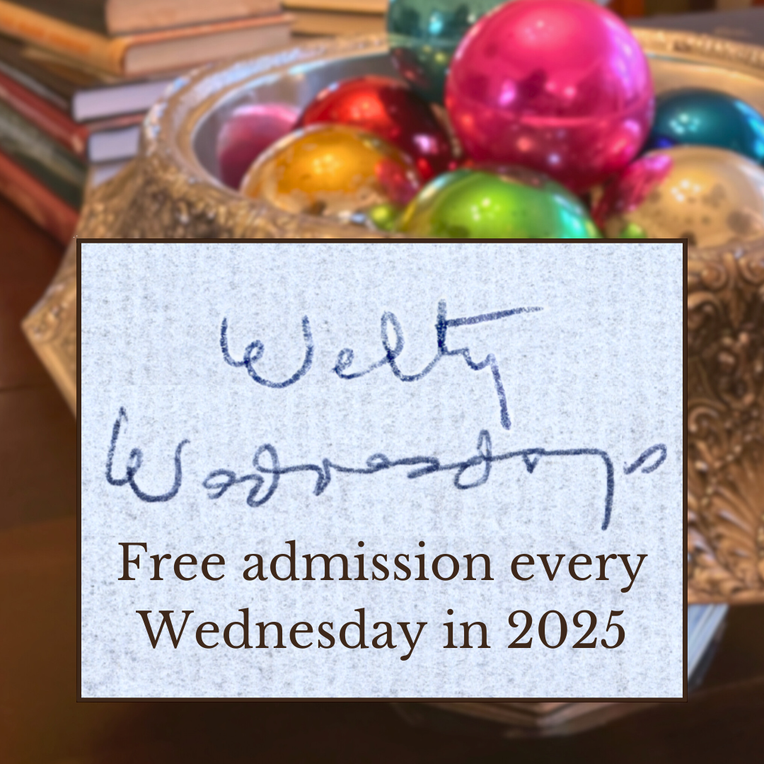 A photo of Eudora's Christmas baubles in a silver vase in the foreground and a stack of books in the background. Superimposed is a box featuring Eudora Welty's handwritten text, 'Welty Wednesdays,' in blue ink on a textured background. Below the handwriting, printed text reads: 'Free admission every Wednesday in 2025.'